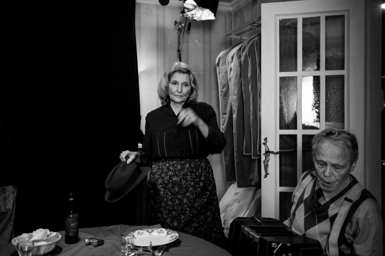 Une comédienne en chapeau, dans la pénombre de l’appartement du tournage